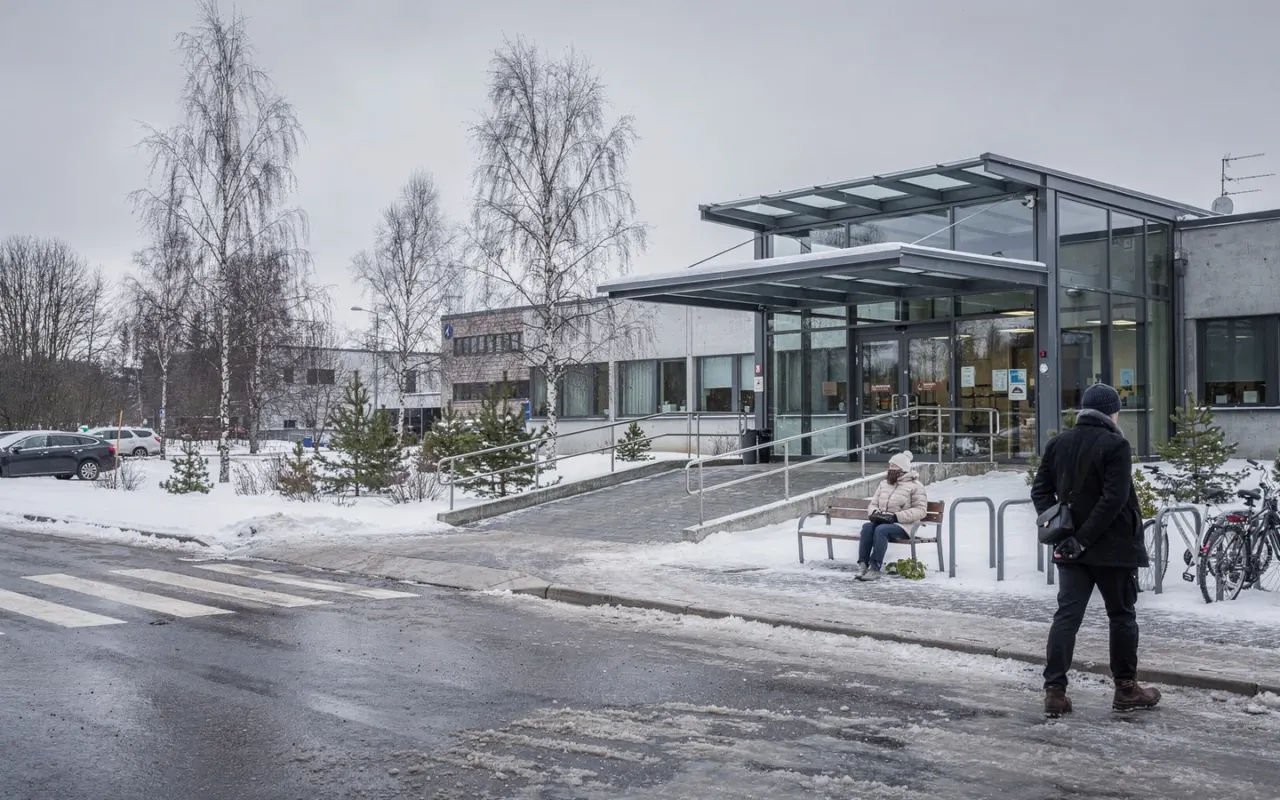 Nykyaikaisen sairaalakampuksen sisäänkäynti talvella, esteetön ramppi ja pysäköinti.